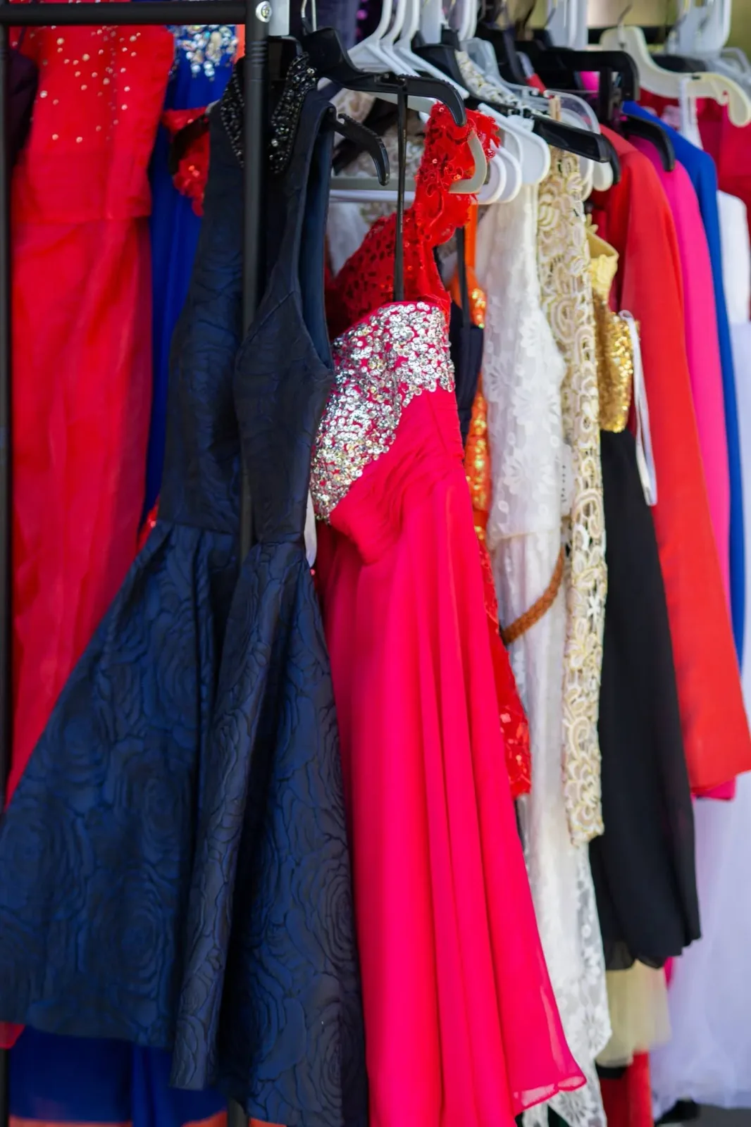 Racks of donated prom dresses in every colour, lined up ready for the drive